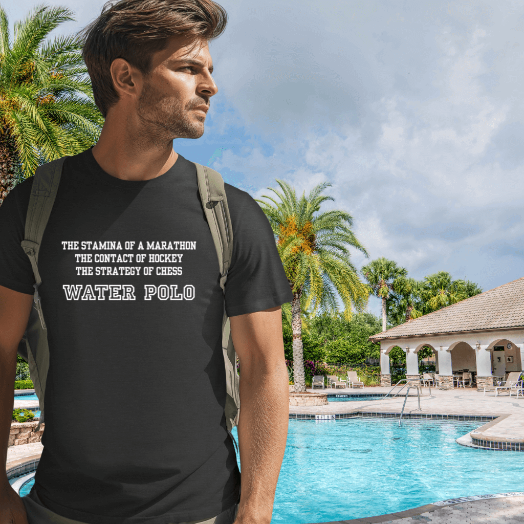 Man wearing a grey water polo t-shirt with text by a poolside with palm trees and a gazebo.
