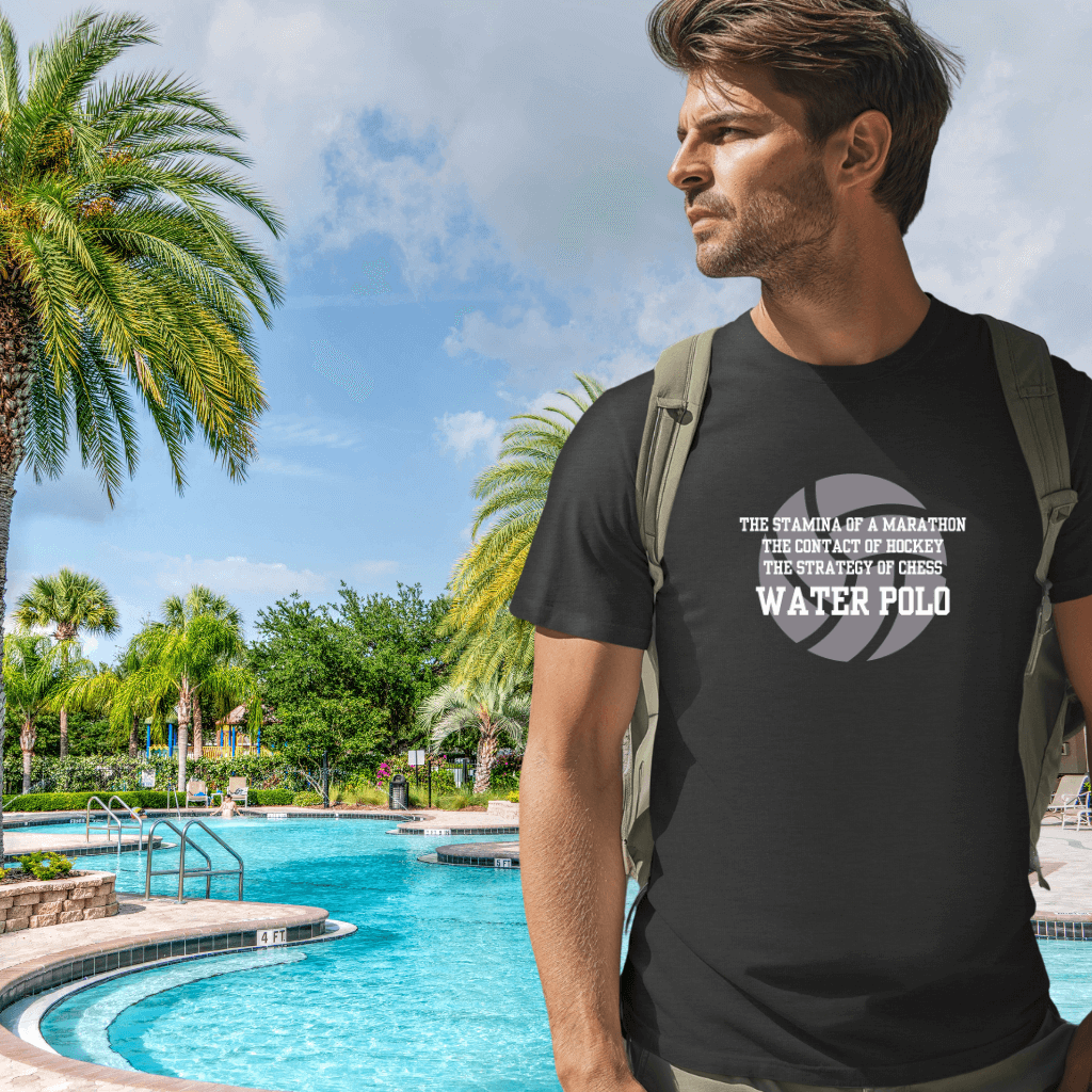 Man wearing a grey water polo t-shirt by a pool with palm trees in the background