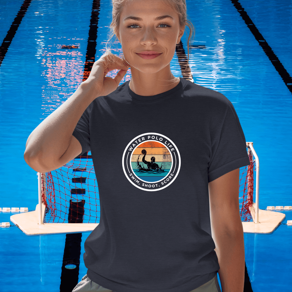 Woman wearing a navy t-shirt with a water polo design in front of a pool.